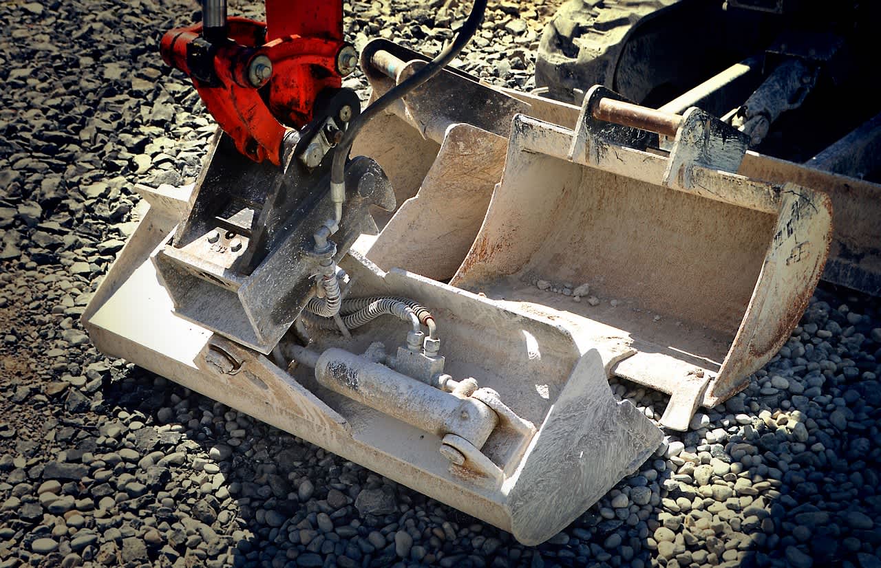 excavator with three bucket attachments around it