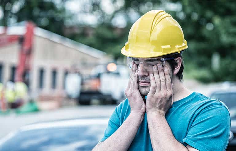 construction worker sleepy rubbing tired face and eyes