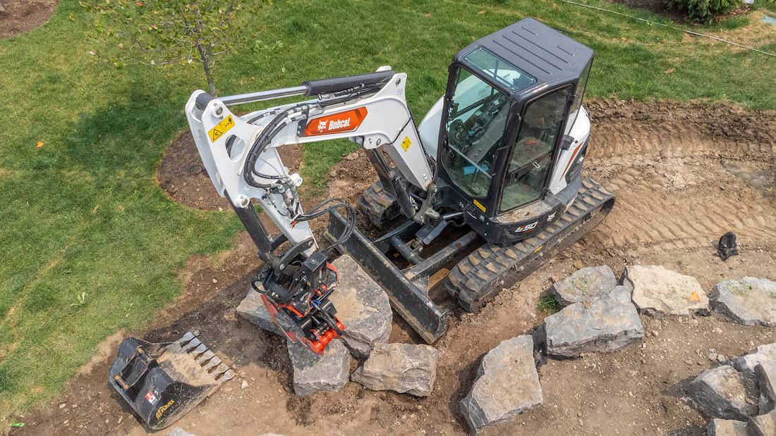 rented mini excavator working on home diy landscape project