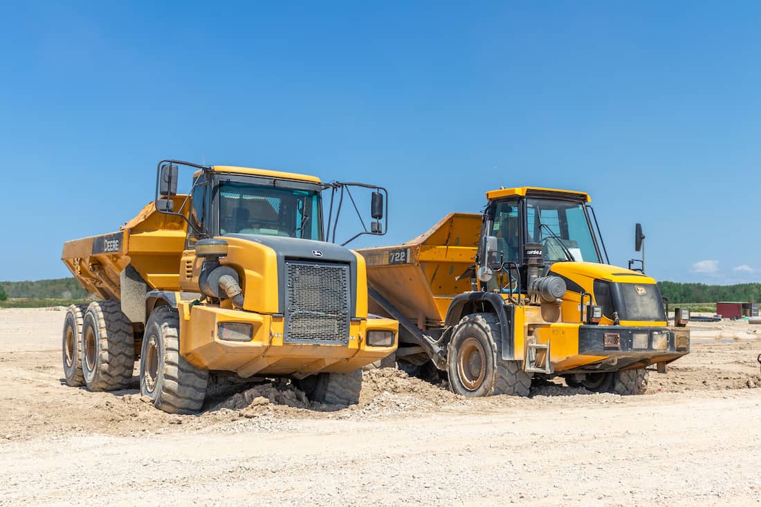 Two rented construction rock trucks parked on a construction site