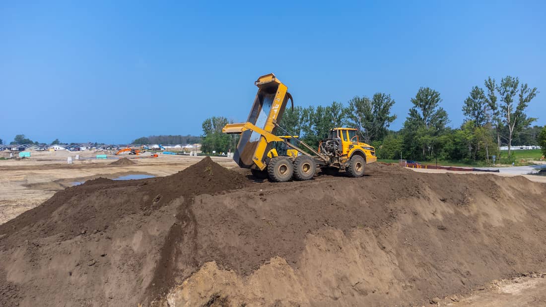 rented rock truck dumping material on a construction site