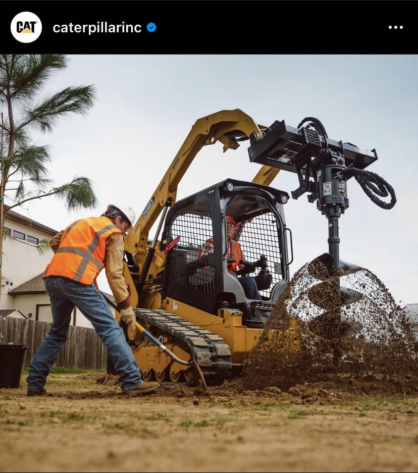 auger on skid steer drilling hole with sand flying