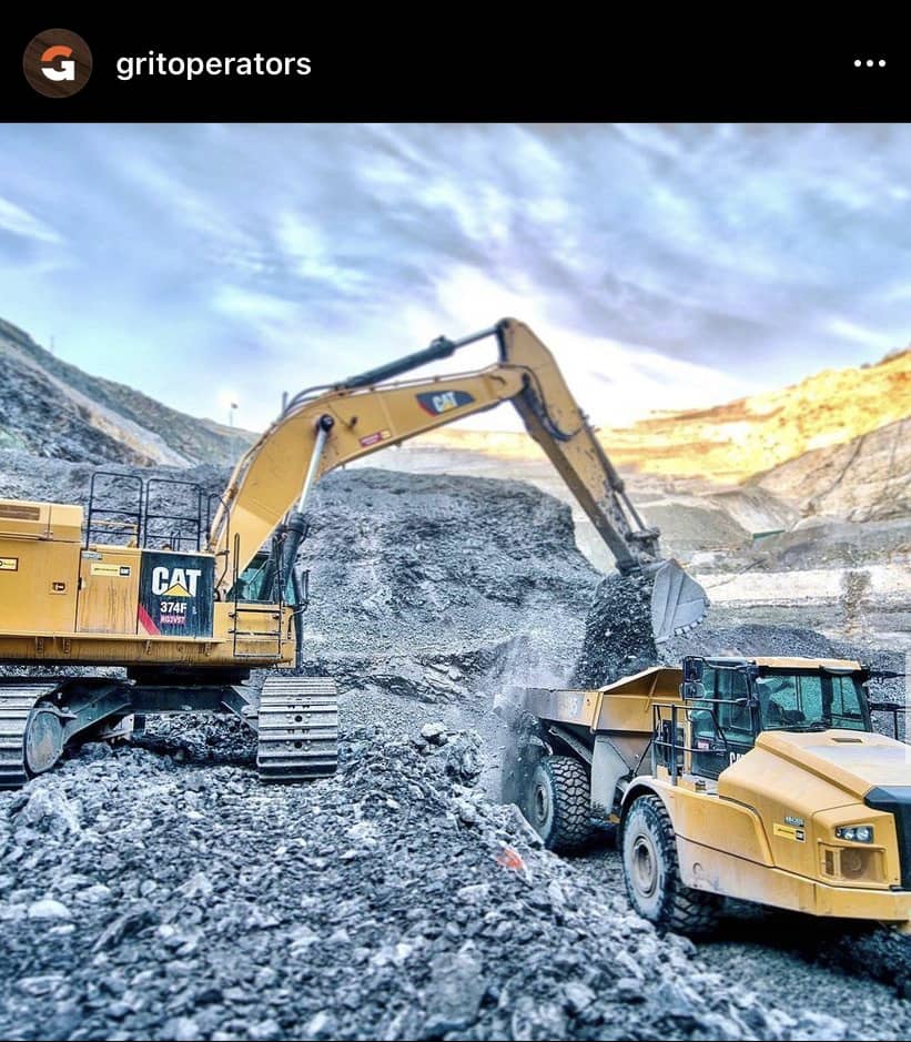 excavator loading a rock truck in the mountains