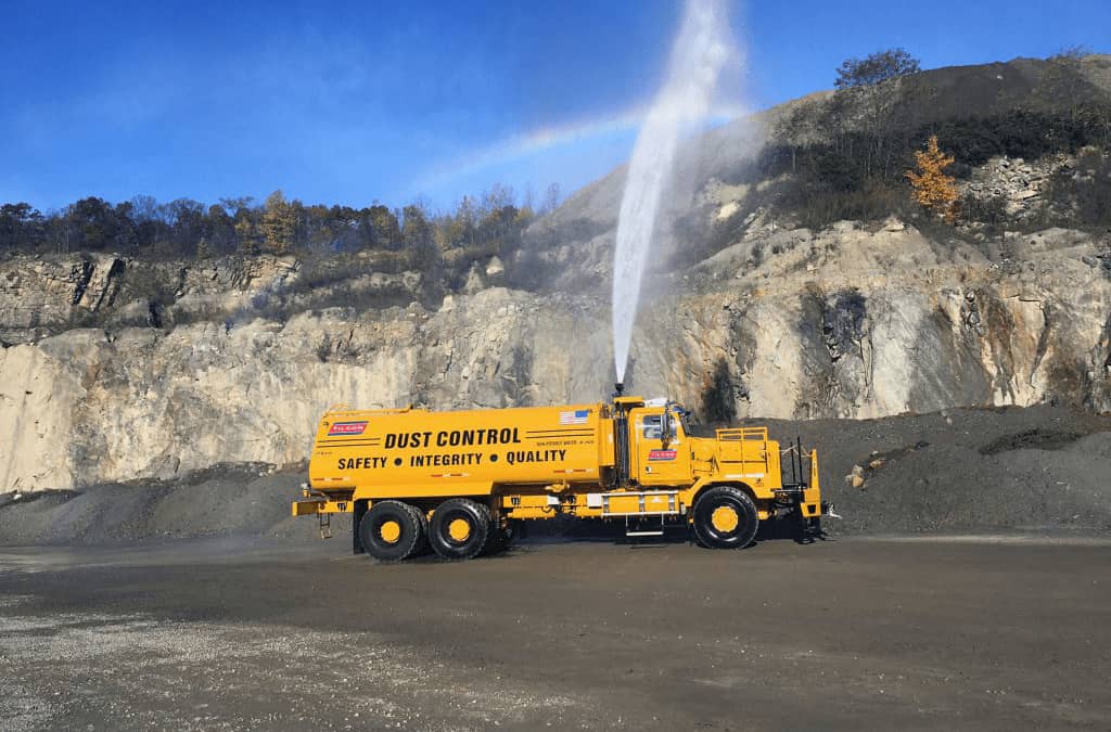 Dust control truck spraying water on a construction site