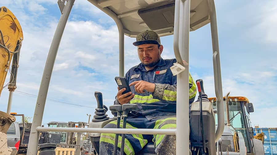 construction equipment operator searching for equipment rentals on a phone