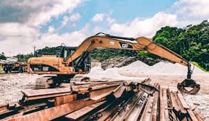 Excavator beside railway tracks.