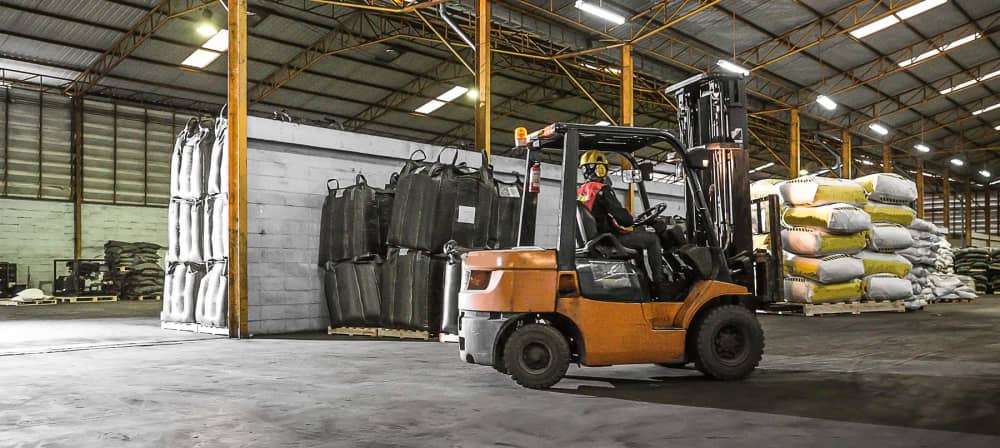 Forklift in warehouse with operator driving indoors