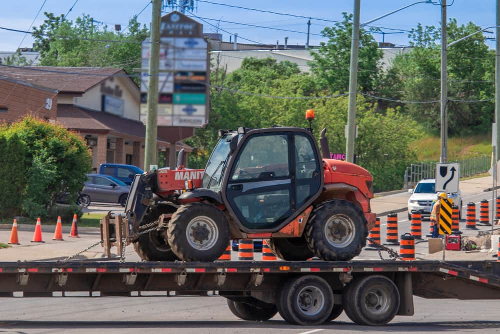 Heavy equipment rental company delivery on truck flat bed