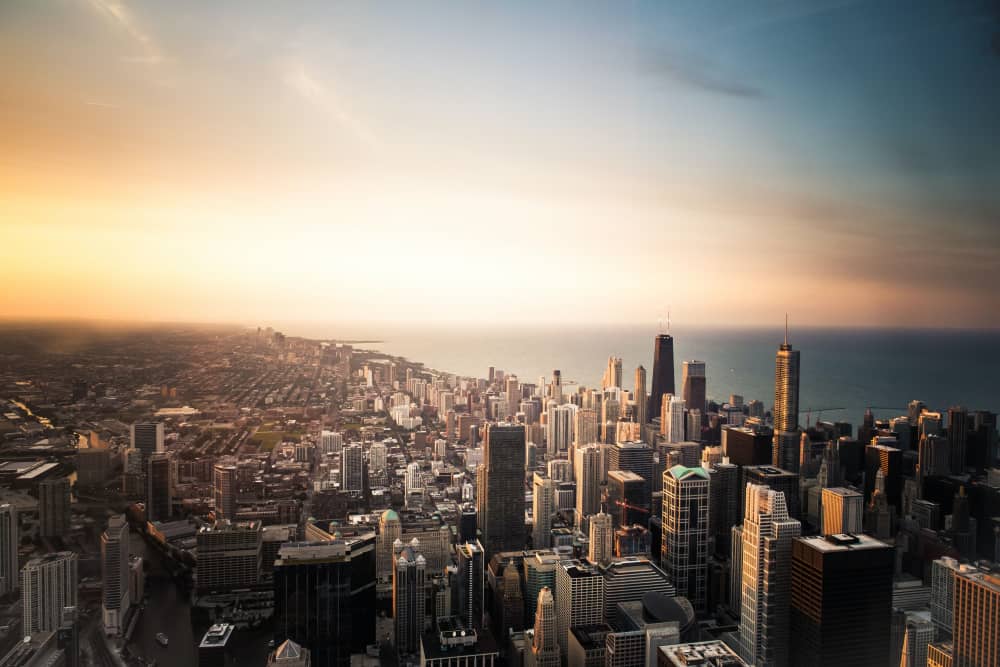 Urban skyline with tall buildings. Sunset in the background.