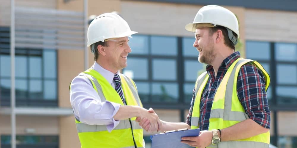 Contractor and subcontractor shaking hands on a jobsite