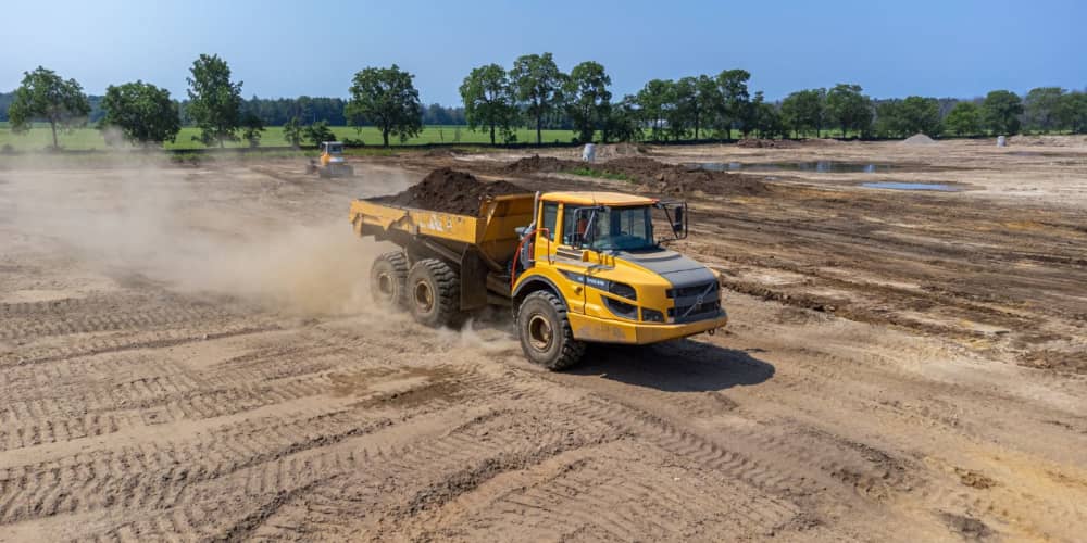 Volvo A25G haul truck driving dirt around a construction site