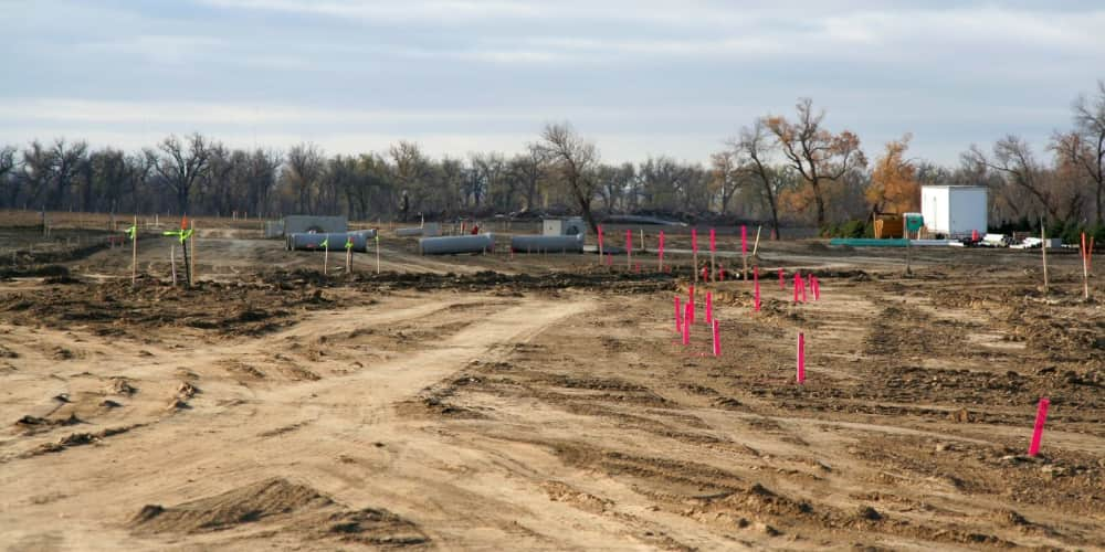 A construction site land preparation project with grade stakes placed across it