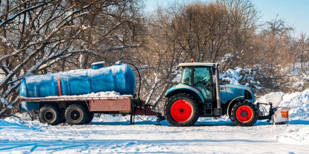 Utility tractor pulling a tank on a trailer