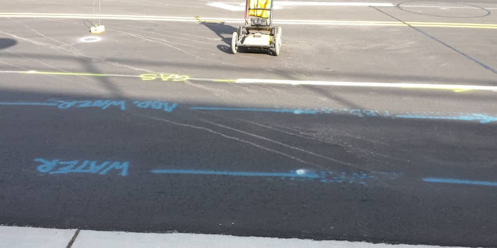 Utility locator markings on a road project including water and gas lines