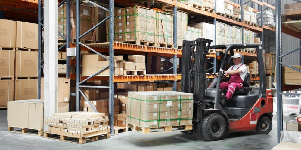 Man on a forklift moving boxes around a warehouse