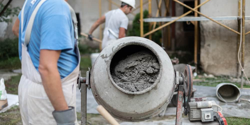 Two workers working with cement