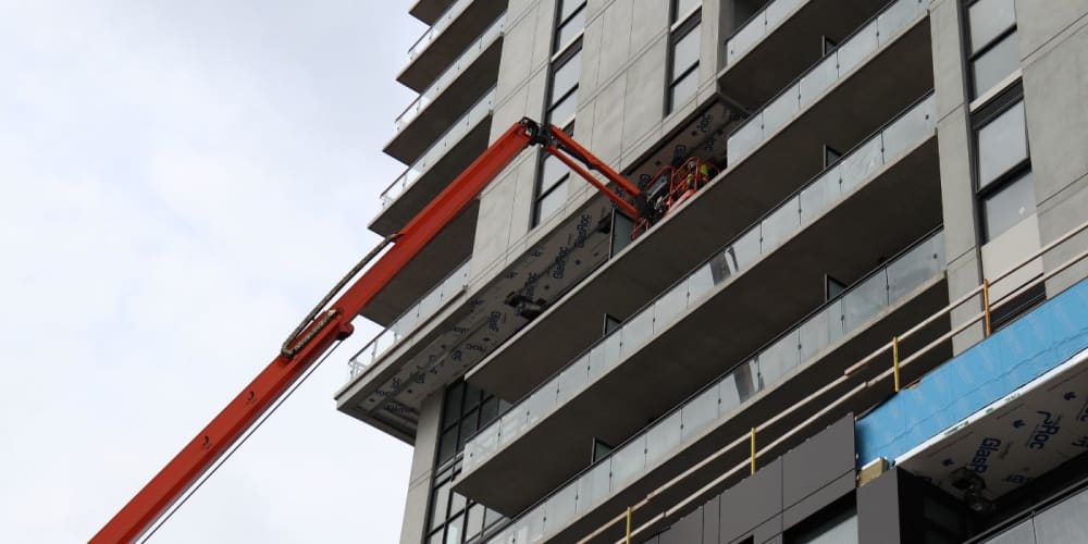 JLG boom lift working on a tall building