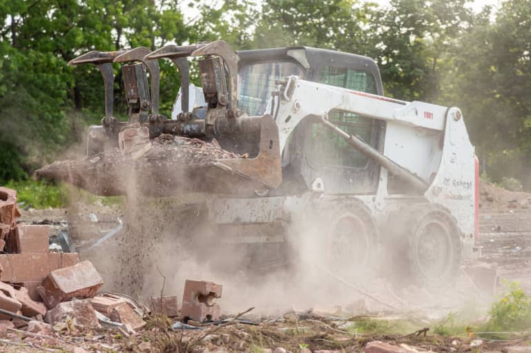 construction dust during demolition project with a skid steer