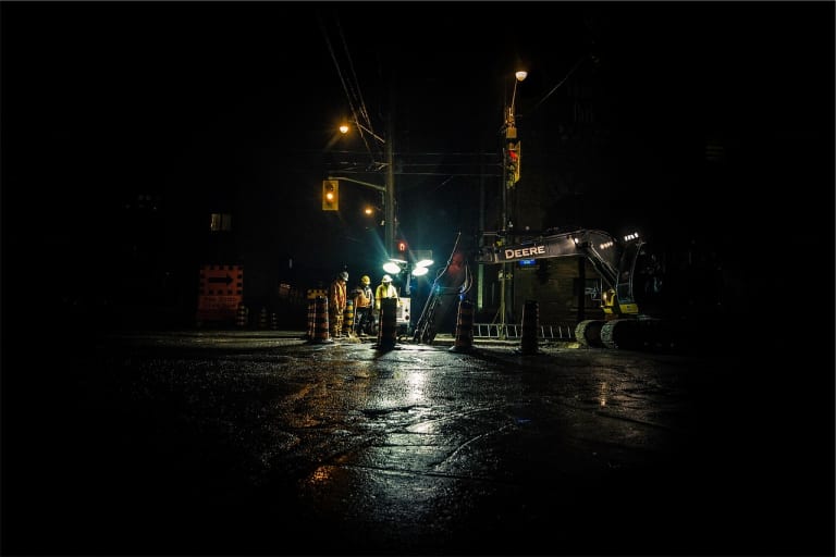 construction workers working at night with light towers