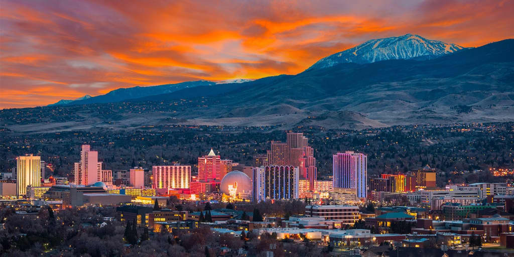 Nighttime, skyline view of downtown Reno in Nevada with mountains in the background