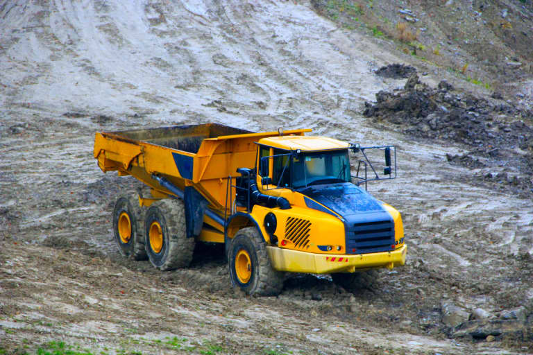 rented articulating dump truck rock truck driving on a construction site