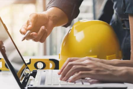 Two construction workers at a computer