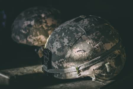 Army helmet close up in dimly lit room.