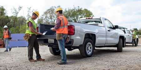 Two men working on the bed of a pickup truck