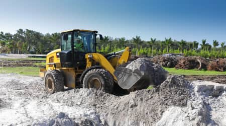 Wheeled front loader carrying rocks in bucket