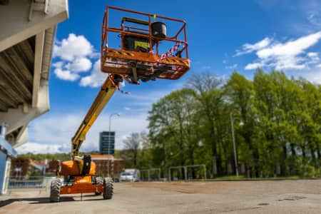 View from underneath a boom lift platform with a blue sky background