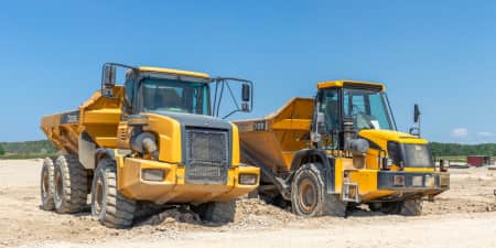 Two articulating dump trucks parked