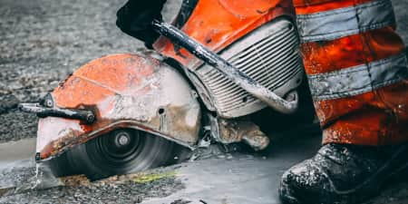 Construction worker cutting concrete with a circular saw