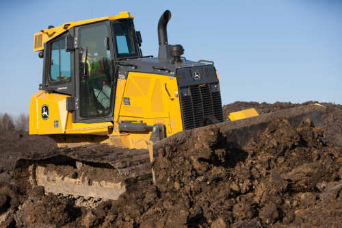 John Deere 700K dozer pushing mud on a construction site