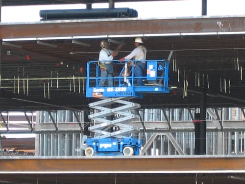 two construction workers on a scissor lift