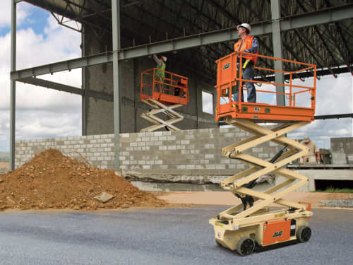 Two scissor lifts with a construction worker on it