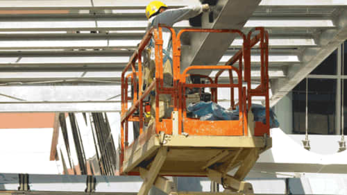 Construction worker wearing ppe working on the ceiling of a project