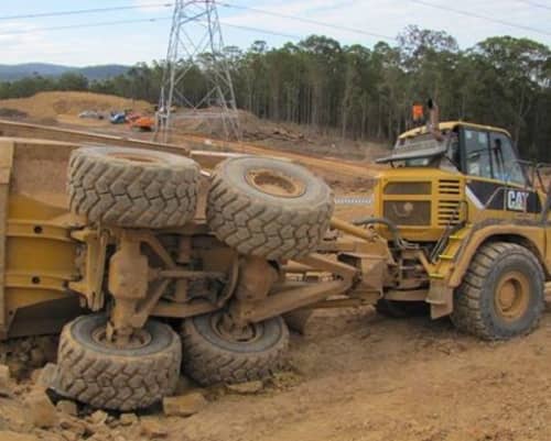 A rock truck whos back end has tipped over