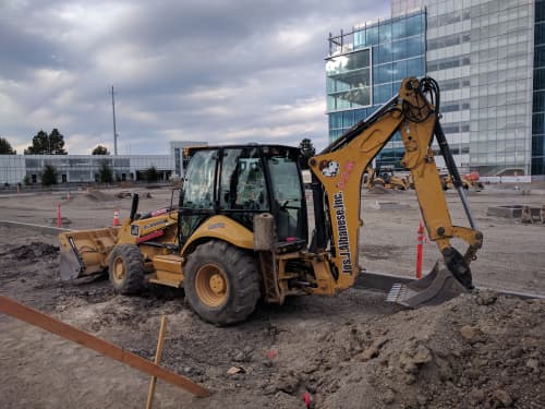 Backhoe on jobsite digging dirt