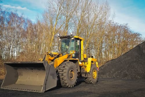 Wheel loader parked in front of dirt pile