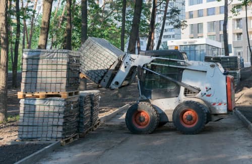skid steer stacking materials with fork attachment