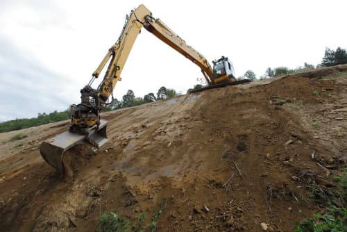 long reach excavator operating on a hill