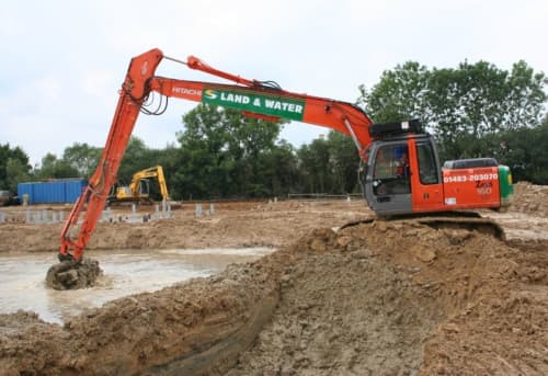 Long reach excavator digging on hill