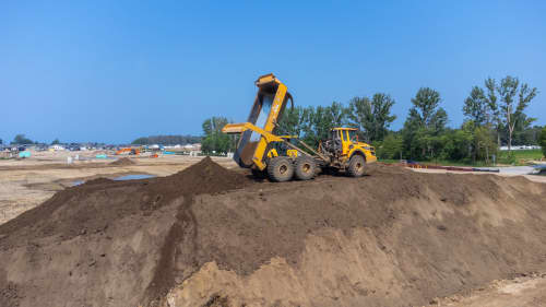 rock truck dumping dirt on a construction site