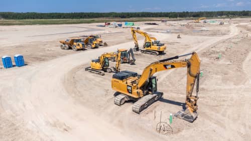 Caterpillar excavator rental dumping dirt in a truck