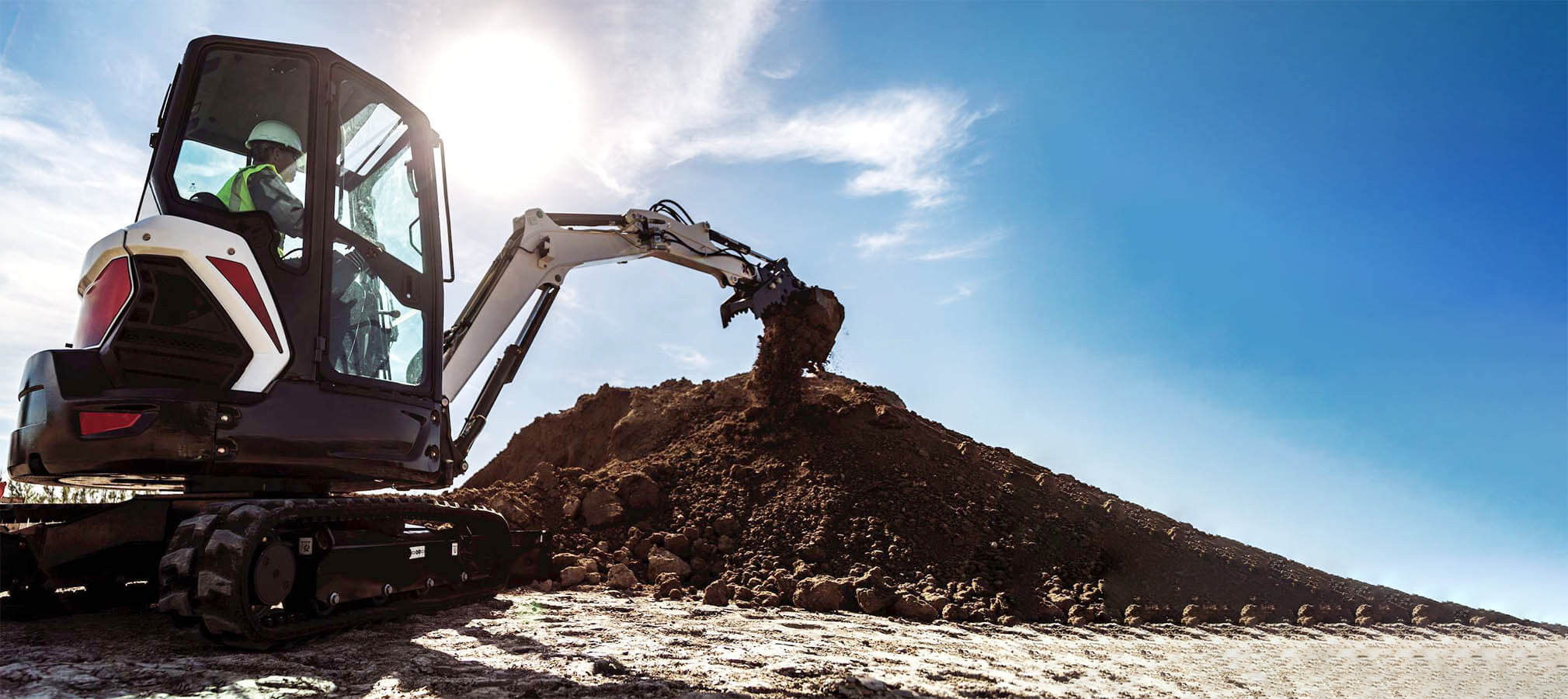 Mini Excavators Dropping Dirt on Construction Site