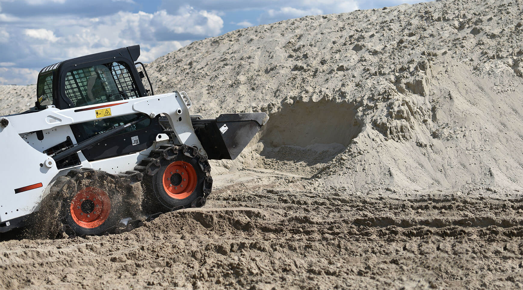 Wheeled Skid Steer Digging in Dirt in Ontario