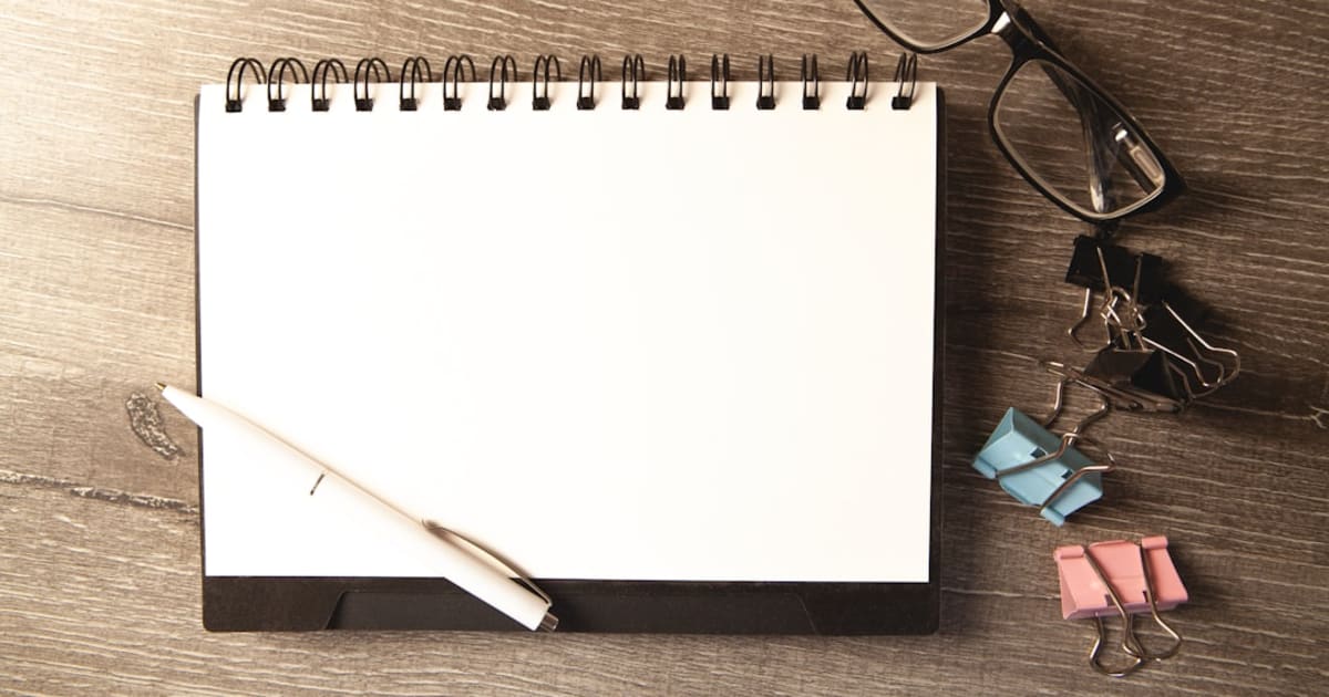 Simple paper checklist and pen on a wooden surface, representing a task manager you pay for once rather than renting access to every month