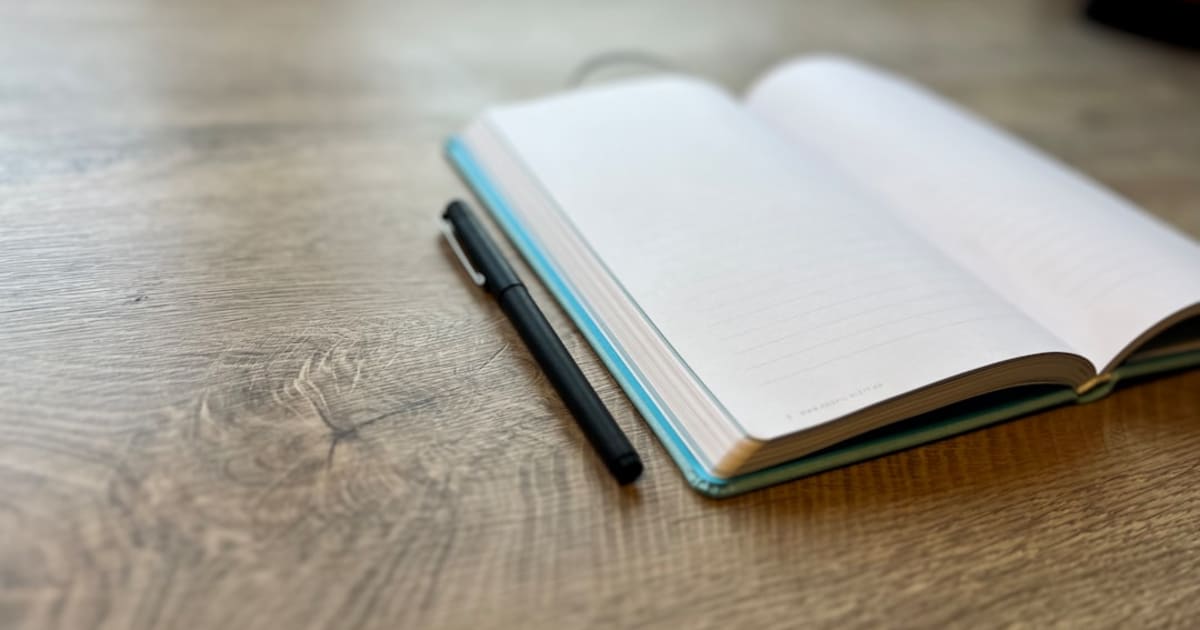 Minimalist clean black notebook and fountain pen on a simple surface, representing the deliberate simplicity and privacy focus of Standard Notes