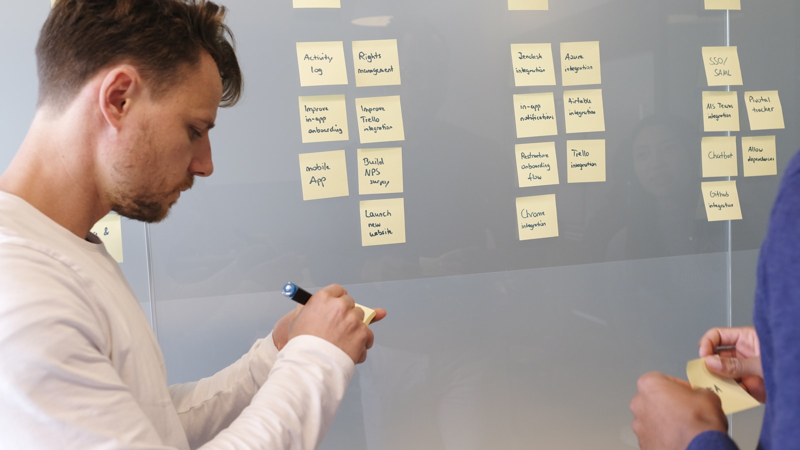 Person organizing a wall of project notes for an AppFlowy and Flow comparison