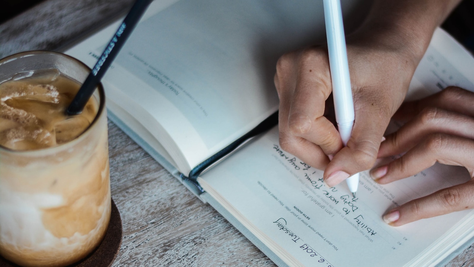 Person writing a notebook entry for a Flow and Evernote comparison